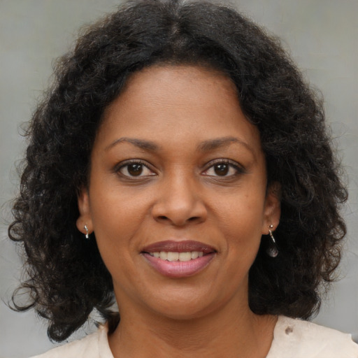 Joyful black young-adult female with medium  brown hair and brown eyes