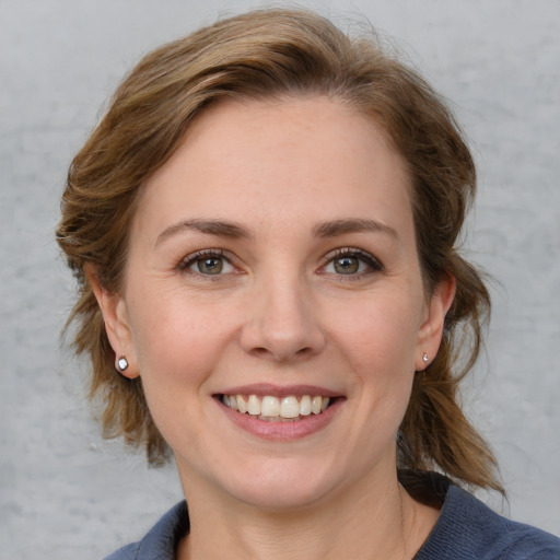 Joyful white young-adult female with medium  brown hair and blue eyes