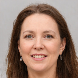 Joyful white adult female with long  brown hair and grey eyes