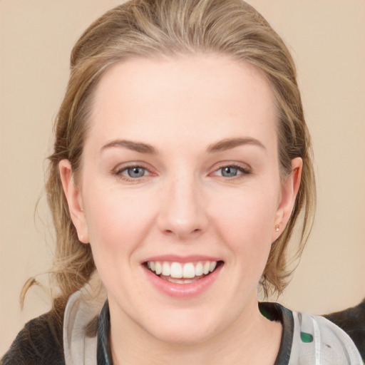 Joyful white young-adult female with medium  brown hair and blue eyes