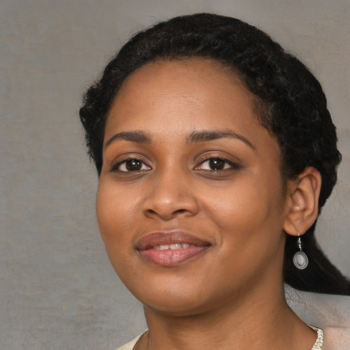 Joyful black young-adult female with medium  black hair and brown eyes