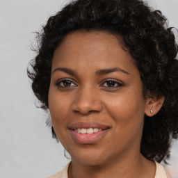 Joyful black young-adult female with long  brown hair and brown eyes