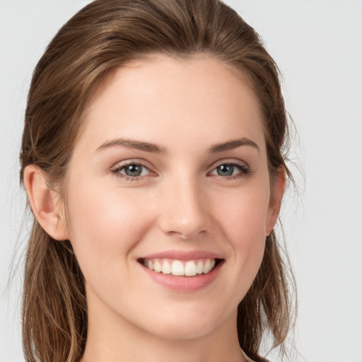 Joyful white young-adult female with long  brown hair and grey eyes