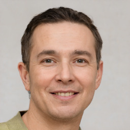 Joyful white adult male with short  brown hair and grey eyes