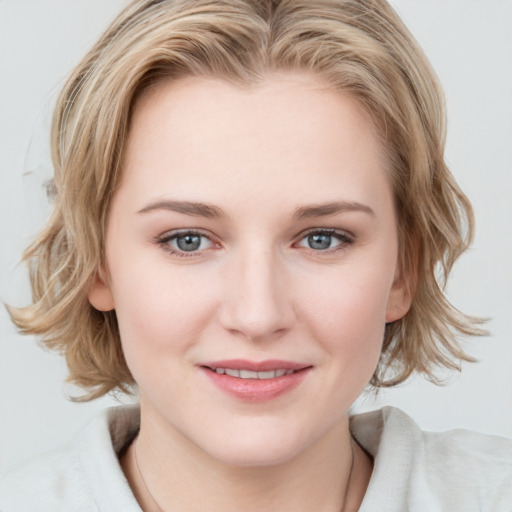 Joyful white young-adult female with medium  brown hair and blue eyes