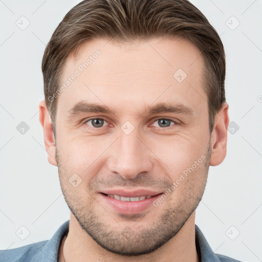 Joyful white young-adult male with short  brown hair and grey eyes