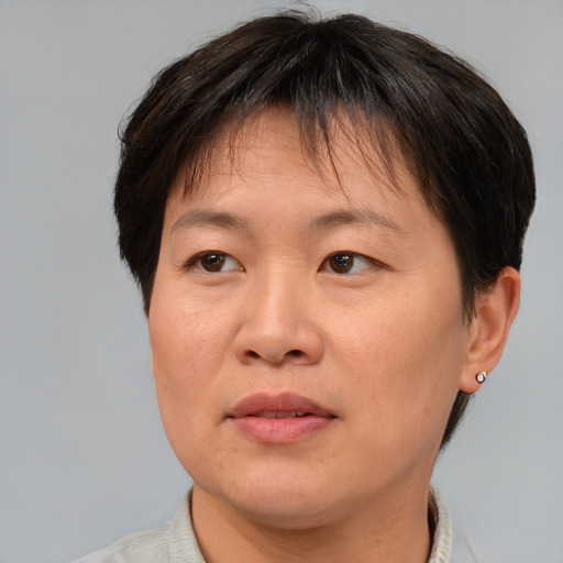 Joyful asian adult female with short  brown hair and brown eyes