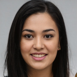 Joyful latino young-adult female with long  brown hair and brown eyes