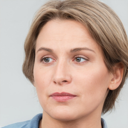 Joyful white adult female with medium  brown hair and grey eyes