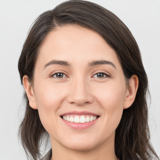 Joyful white young-adult female with long  brown hair and brown eyes