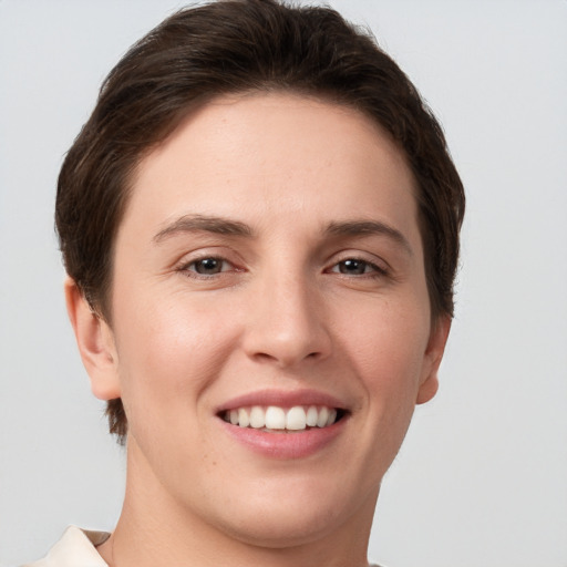 Joyful white young-adult female with short  brown hair and grey eyes