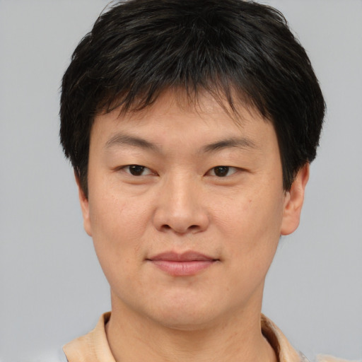 Joyful asian young-adult male with short  brown hair and brown eyes