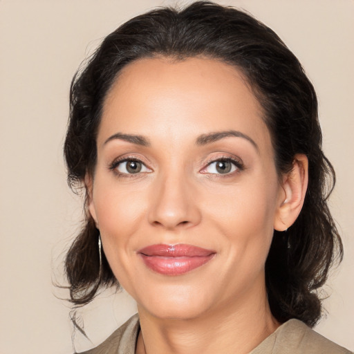 Joyful latino young-adult female with medium  brown hair and brown eyes