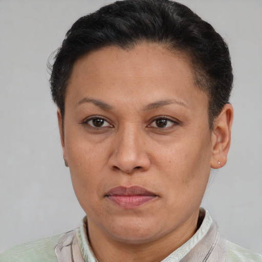Joyful latino adult female with short  brown hair and brown eyes