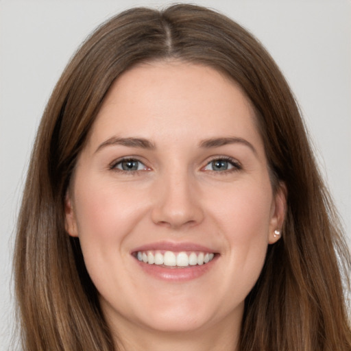 Joyful white young-adult female with long  brown hair and brown eyes