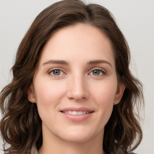 Joyful white young-adult female with medium  brown hair and green eyes