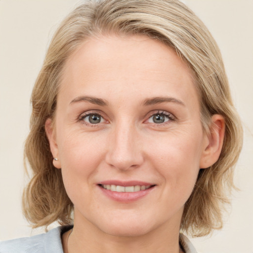 Joyful white adult female with medium  brown hair and blue eyes