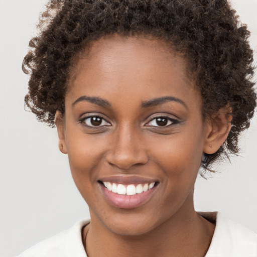 Joyful black young-adult female with short  brown hair and brown eyes