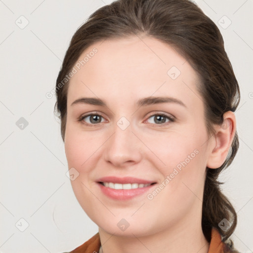 Joyful white young-adult female with medium  brown hair and grey eyes