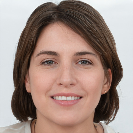 Joyful white young-adult female with medium  brown hair and grey eyes