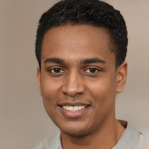 Joyful black young-adult male with short  black hair and brown eyes