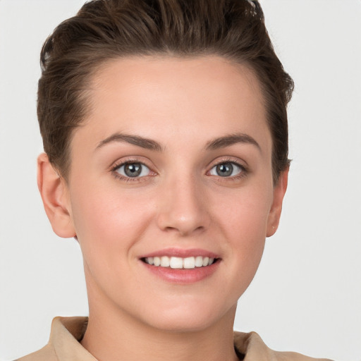 Joyful white young-adult female with short  brown hair and grey eyes