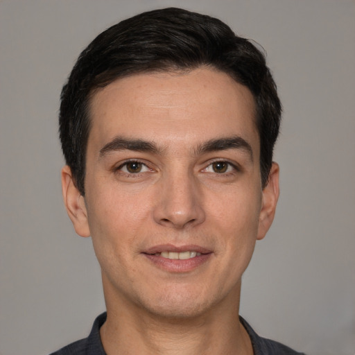 Joyful white young-adult male with short  black hair and brown eyes