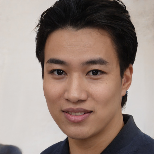 Joyful asian young-adult male with short  black hair and brown eyes