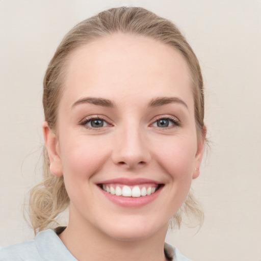 Joyful white young-adult female with medium  brown hair and blue eyes