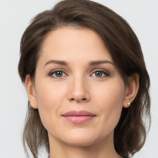 Joyful white young-adult female with medium  brown hair and grey eyes