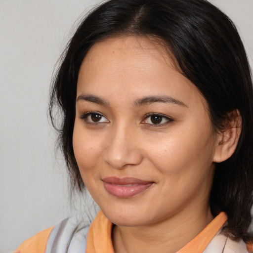 Joyful asian young-adult female with medium  brown hair and brown eyes