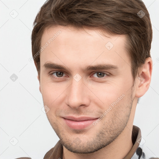 Joyful white young-adult male with short  brown hair and grey eyes