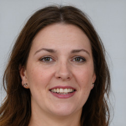 Joyful white adult female with long  brown hair and grey eyes