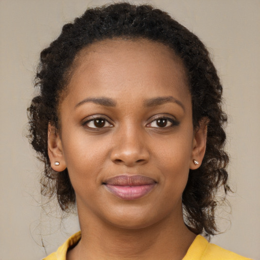 Joyful black young-adult female with medium  brown hair and brown eyes