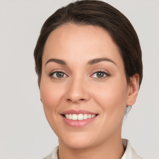 Joyful white young-adult female with short  brown hair and grey eyes