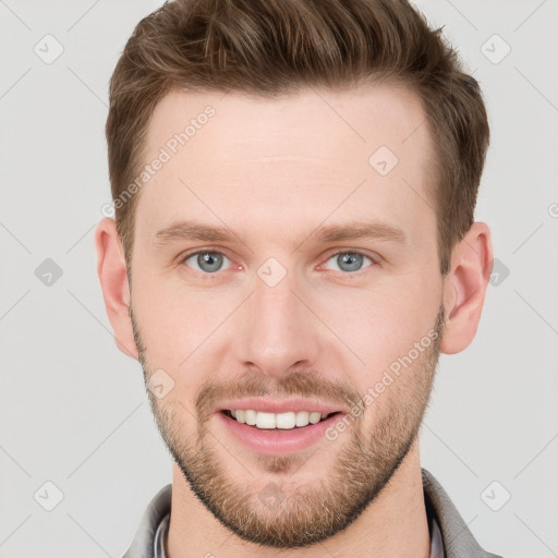 Joyful white young-adult male with short  brown hair and grey eyes