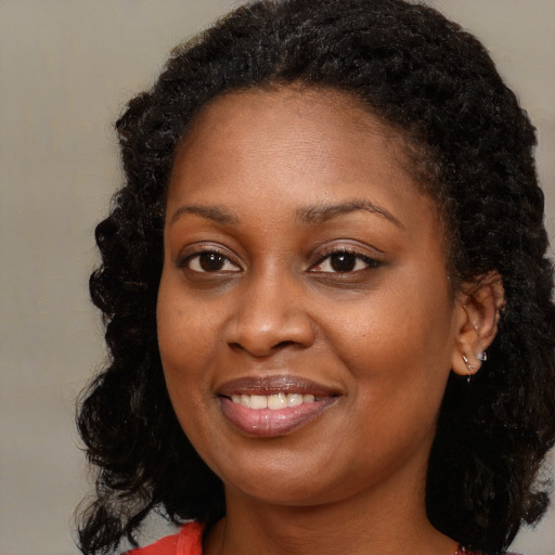 Joyful black young-adult female with long  brown hair and brown eyes