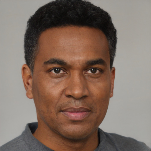 Joyful black adult male with short  black hair and brown eyes