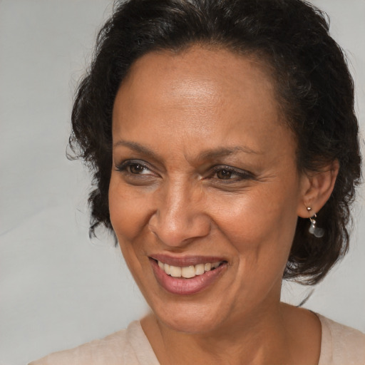 Joyful black adult female with medium  brown hair and brown eyes