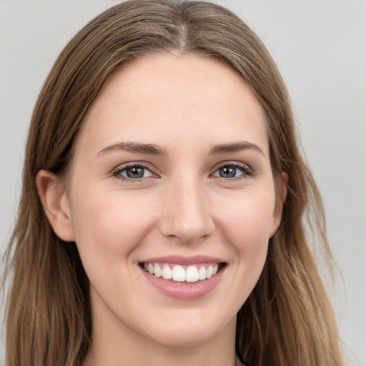 Joyful white young-adult female with long  brown hair and grey eyes