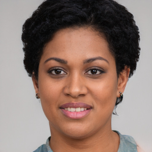 Joyful black young-adult female with short  black hair and brown eyes