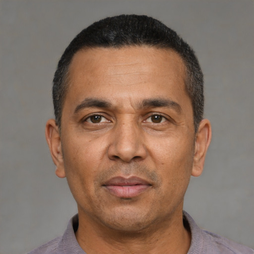 Joyful latino adult male with short  black hair and brown eyes