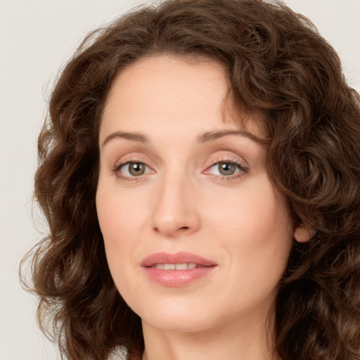 Joyful white young-adult female with long  brown hair and green eyes