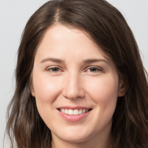 Joyful white young-adult female with long  brown hair and brown eyes