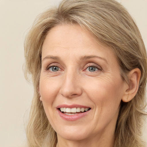 Joyful white adult female with long  brown hair and green eyes