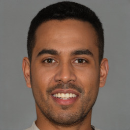 Joyful latino young-adult male with short  brown hair and brown eyes