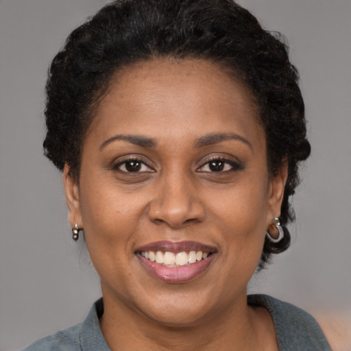 Joyful latino adult female with short  brown hair and brown eyes