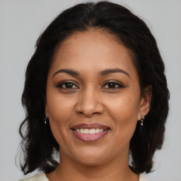 Joyful latino adult female with medium  brown hair and brown eyes