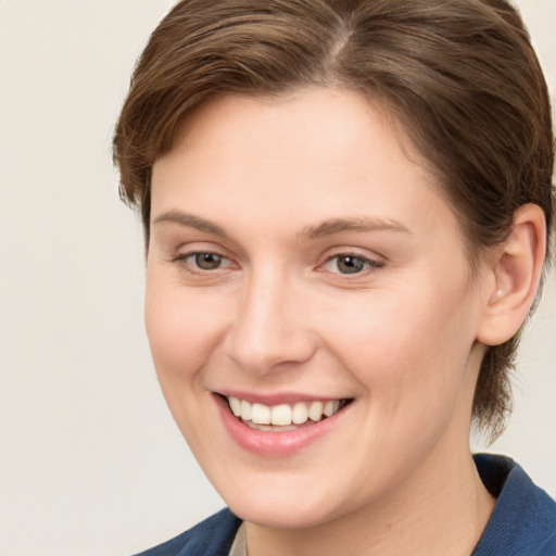 Joyful white young-adult female with medium  brown hair and grey eyes