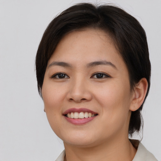 Joyful asian young-adult female with short  brown hair and brown eyes